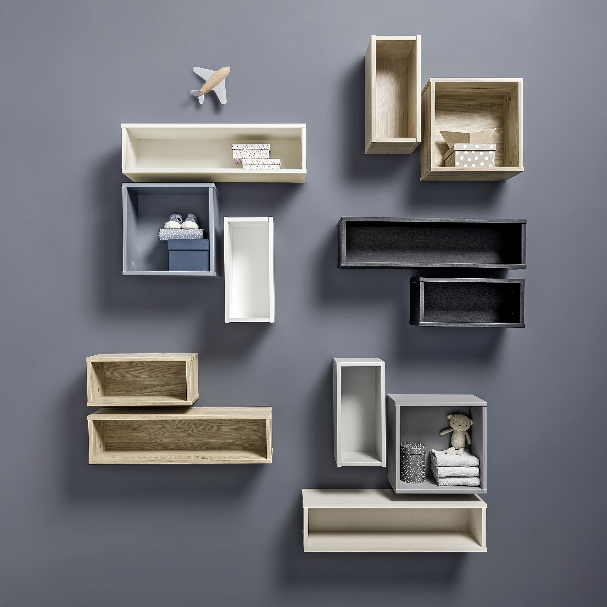 An der Wand befestigte Regale in verschiedenen Formen, Farben und Größen, die kleine Dekorationsgegenstände aufnehmen.