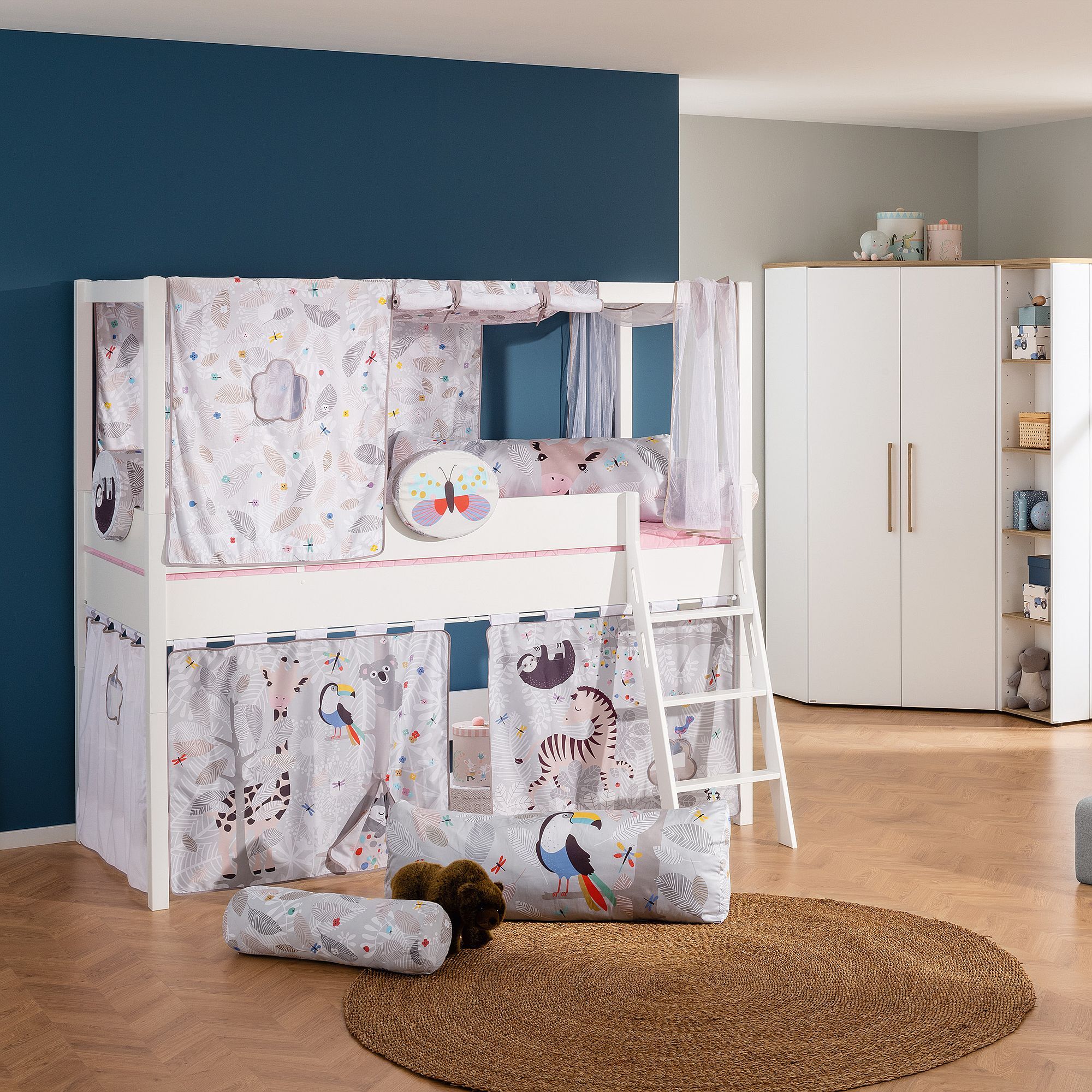 Kinderetagenbett mit verspielten Tiervorhängen und Leiter in einem gemütlichen Zimmer.
