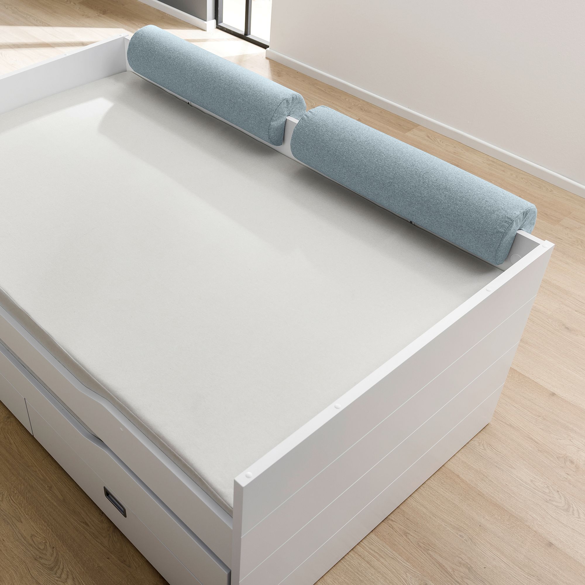 Comfort-Rolle 85,30 x Ø 20 cm, Mikrofaser Aschblau Ein Bett mit einem hellblauen, zylindrischen Kissen an der Hinterkante.
