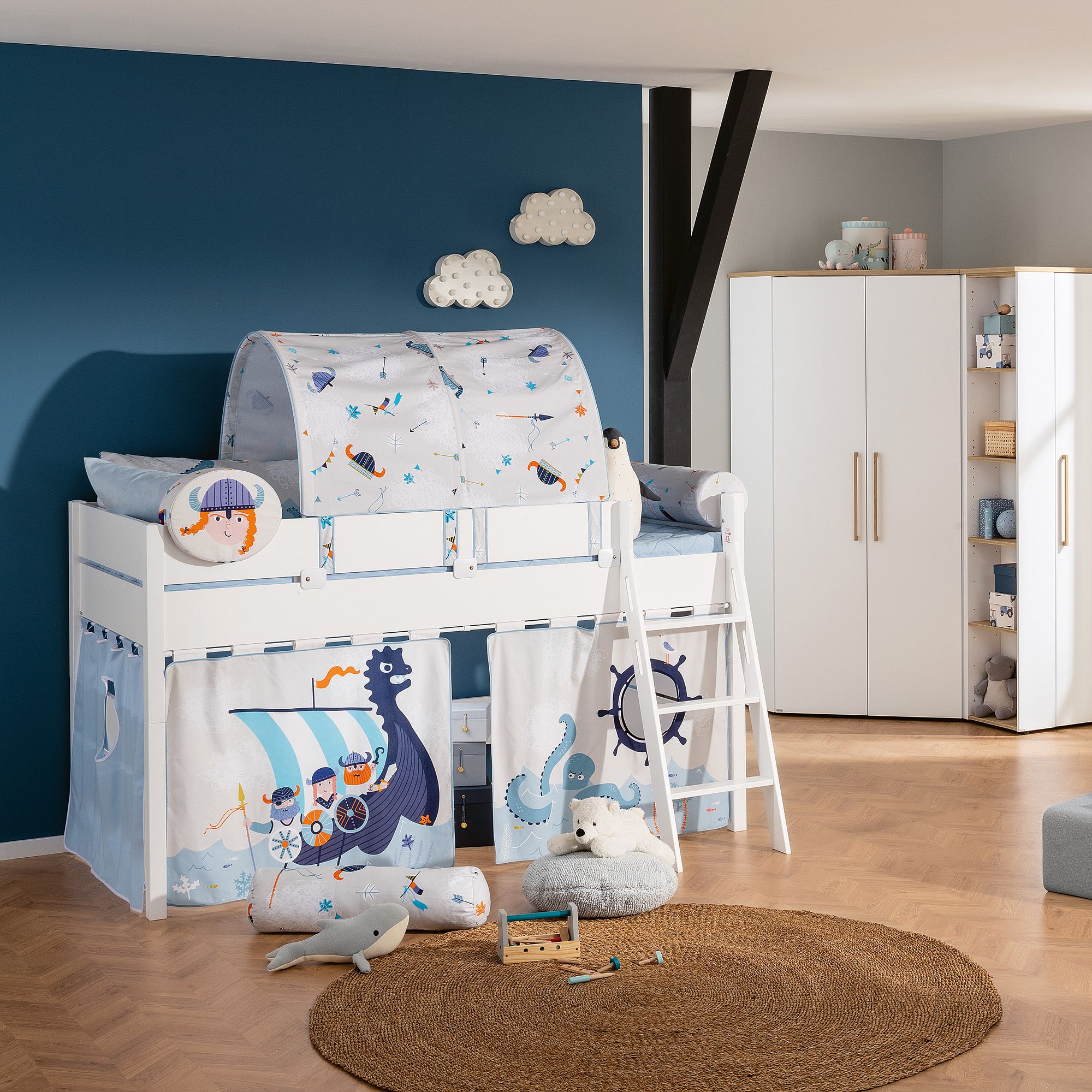 Kinderzimmer mit wikingerzeitlichem Hochbett, Spielzeug und blauer Wanddekoration.