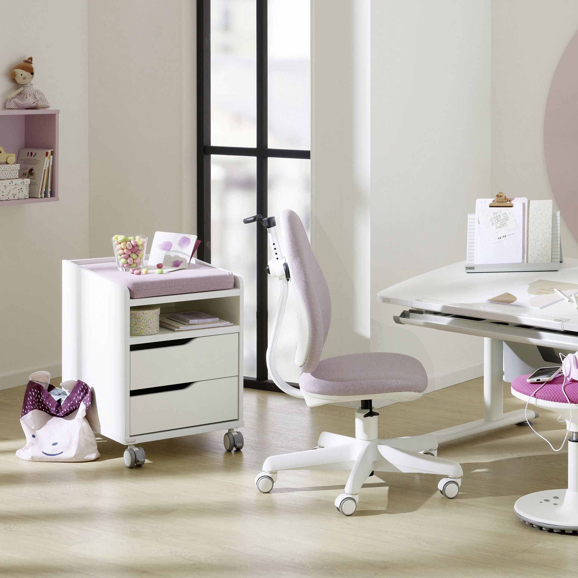 Moderner Arbeitsbereich für Kinder mit rosa Stuhl, Schreibtisch und Schubladen.