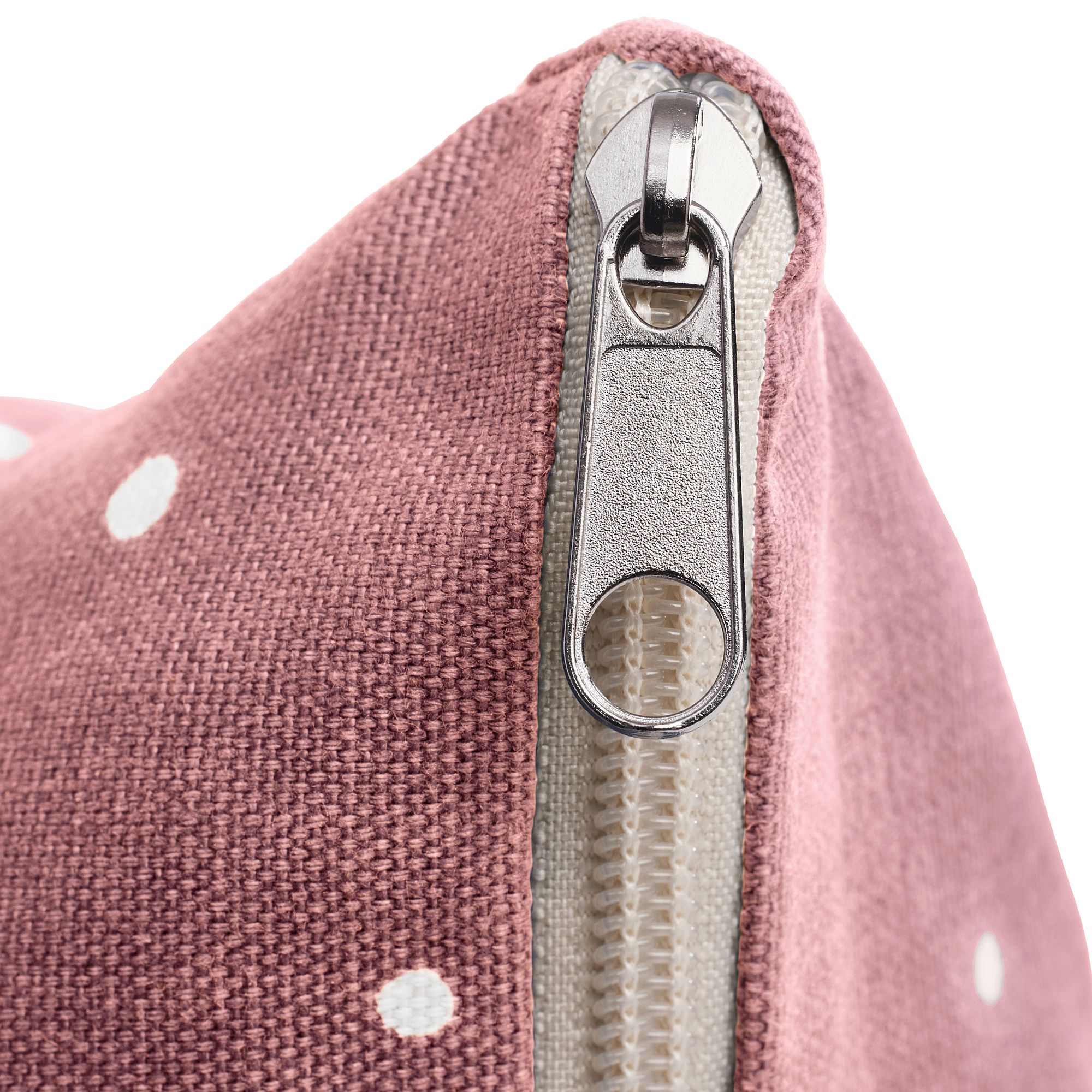 Nahaufnahme eines Beutels aus rosa gepunktetem Stoff mit einem teilweise geöffneten Metallreißverschluss.
