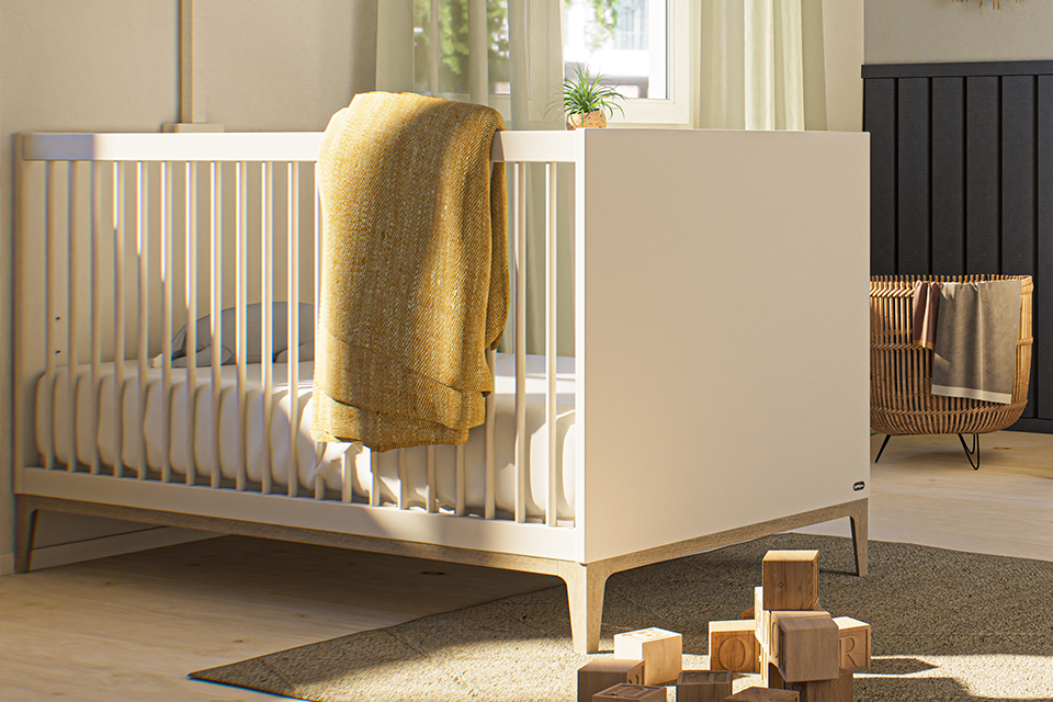 Modernes weißes Kinderbett mit einer gelben Decke, Holzklötzen und natürlichem Licht.