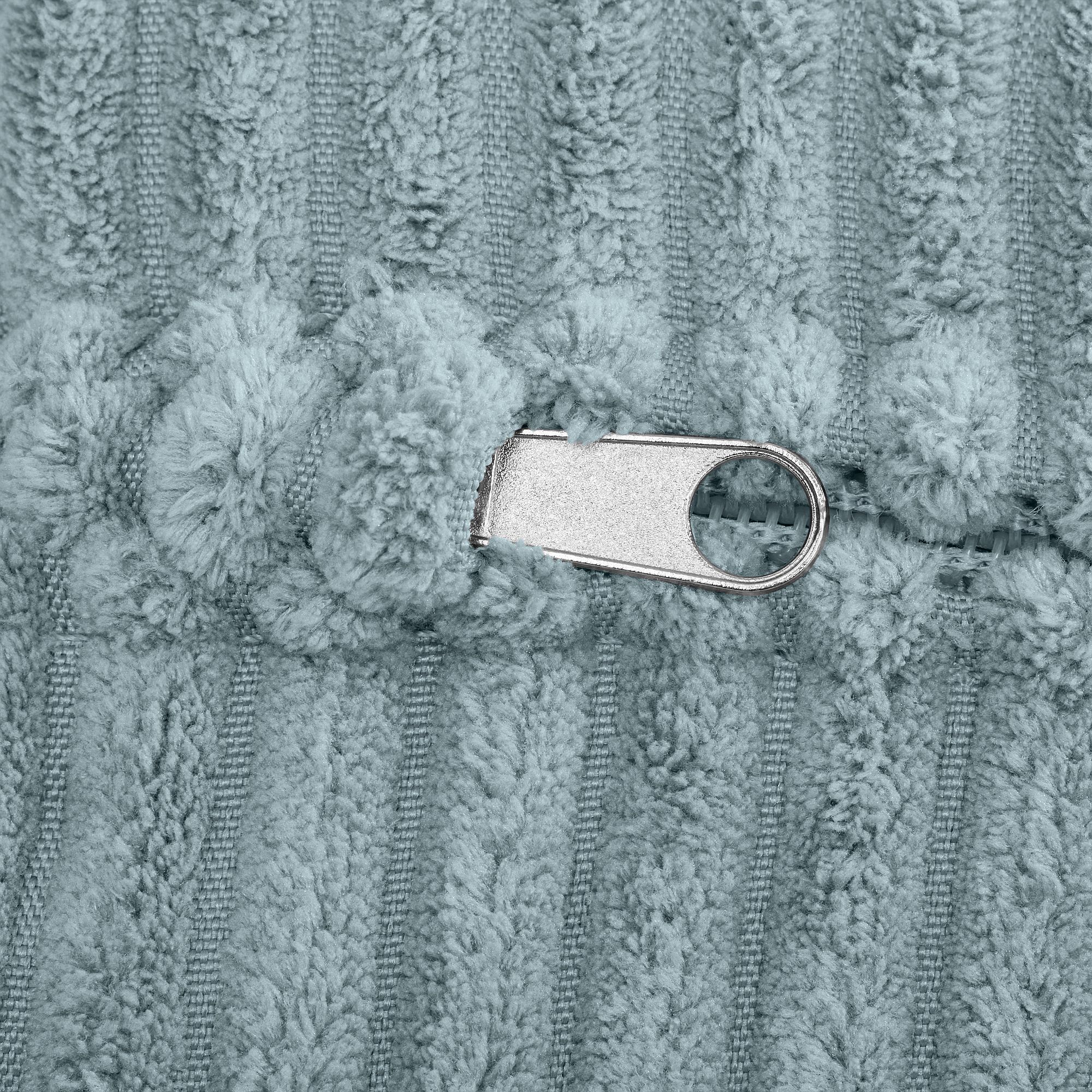 Nahaufnahme eines metallischen Reißverschlusses auf hellblauem, strukturiertem Stoff.