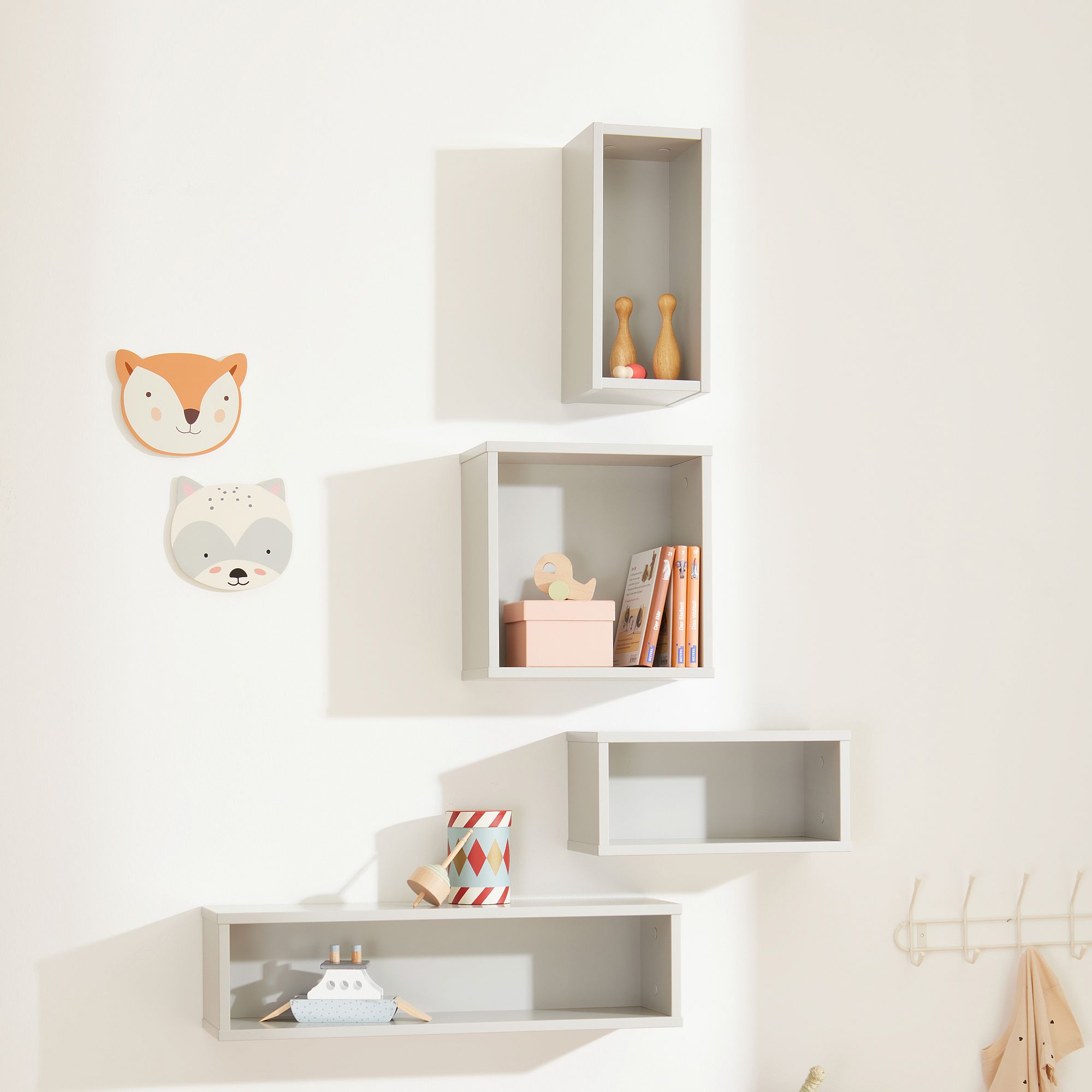 Wandregale mit Spielzeug, Büchern und Dekorationen mit Tiergesichtern in einem Kinderzimmer.