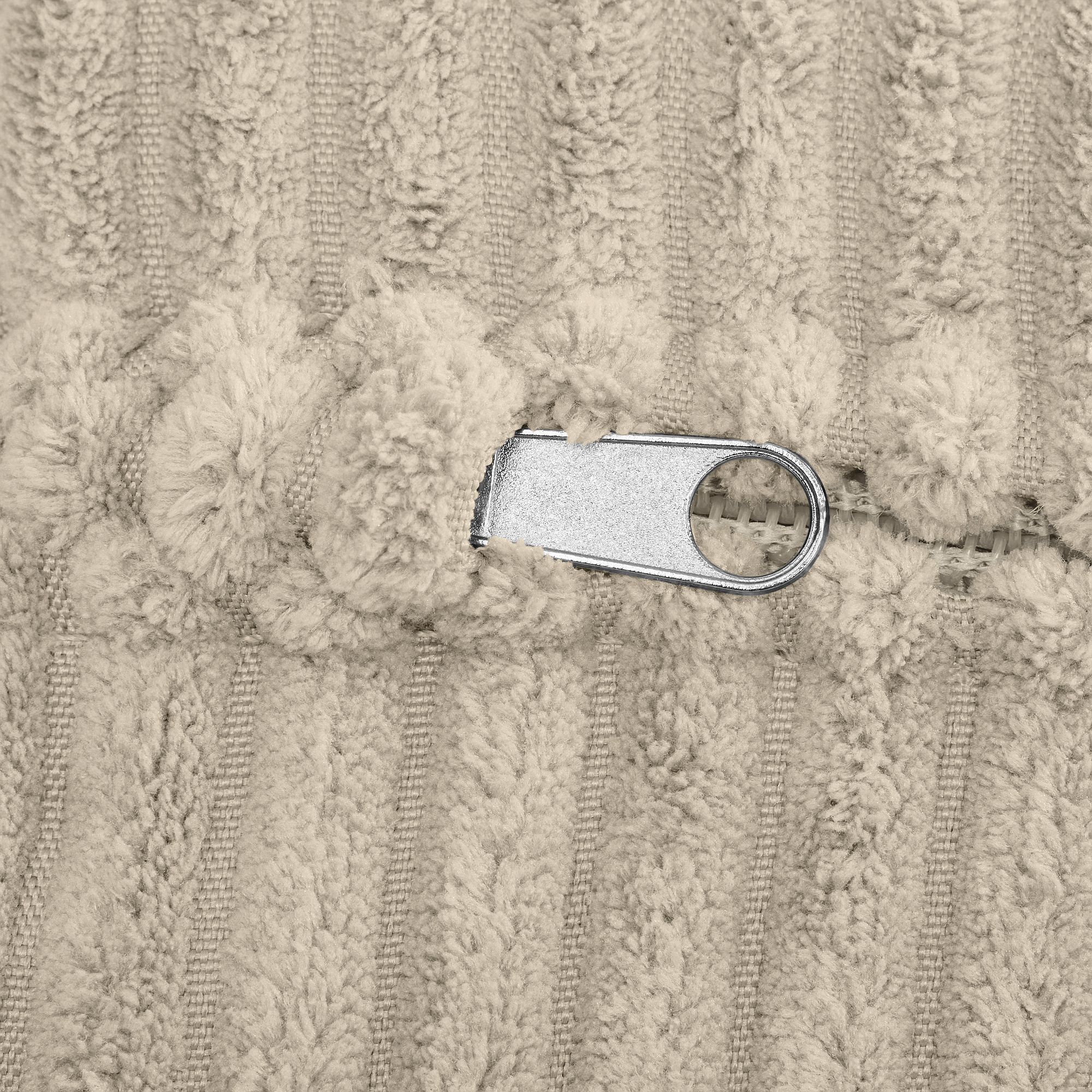 Nahaufnahme eines silbernen Reißverschlusses auf beigem, strukturiertem Stoff.