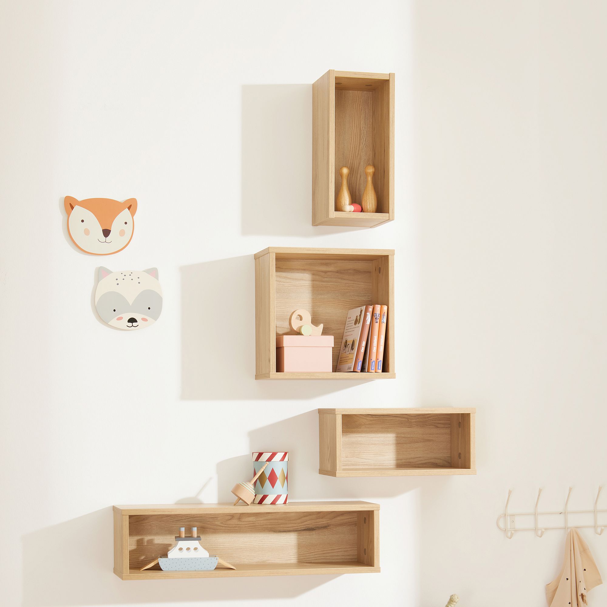 Wandregale aus Holz mit Spielzeug und Büchern, Wanddekoration mit Fuchs und Waschbär.