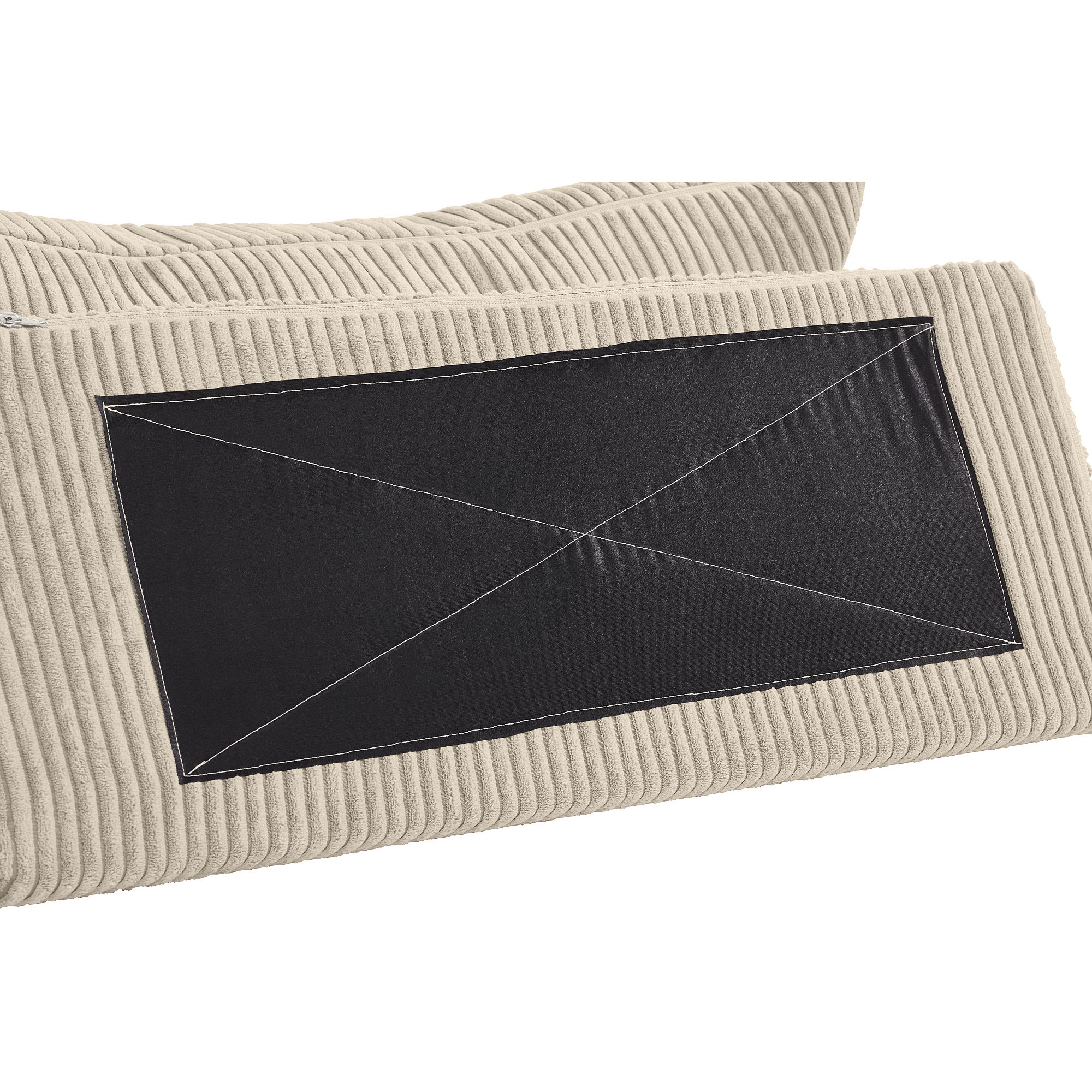 Beigefarbenes Rippenkissen mit einem großen schwarzen rechteckigen Aufnäher und weißen Nähten.