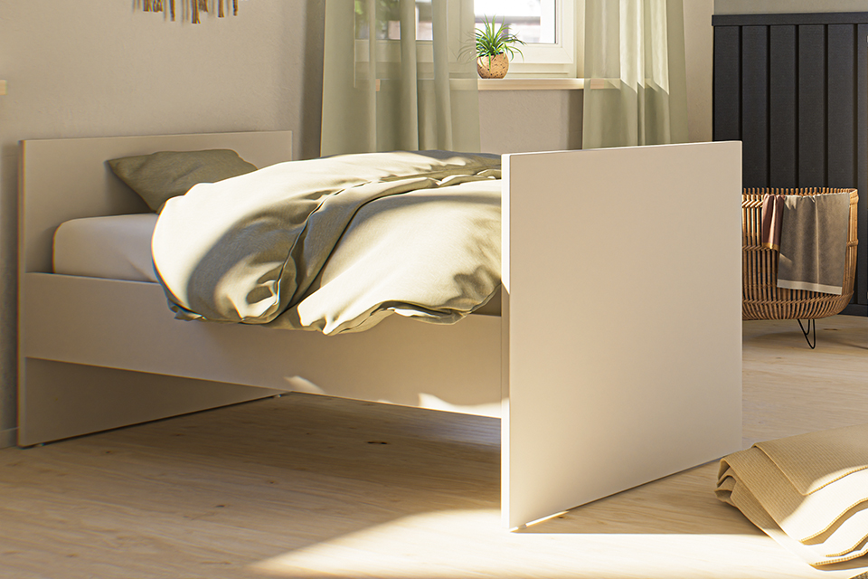 Sonnendurchflutetes, minimalistisches Schlafzimmer mit einem ungemachten Bett und heller Bettwäsche.