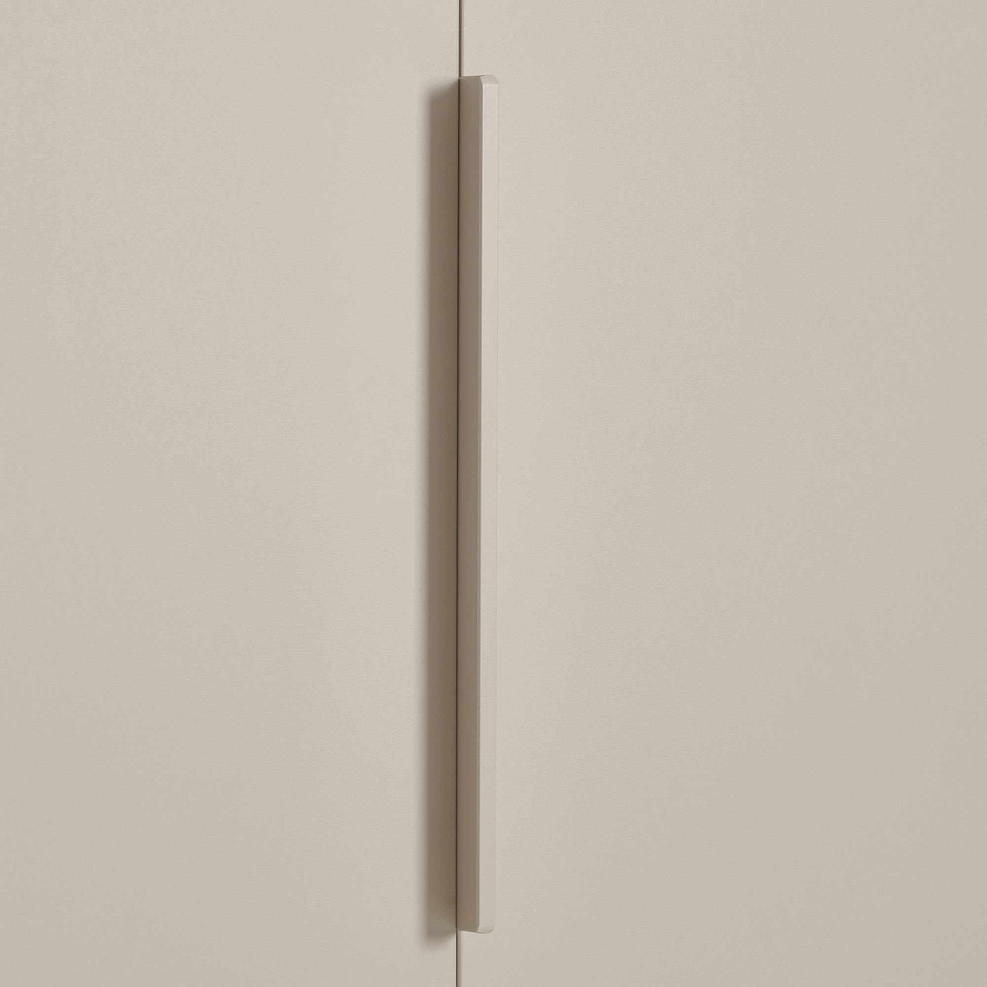 Minimalistische beigefarbene Schranktür mit einem vertikalen Griff in der Mitte.