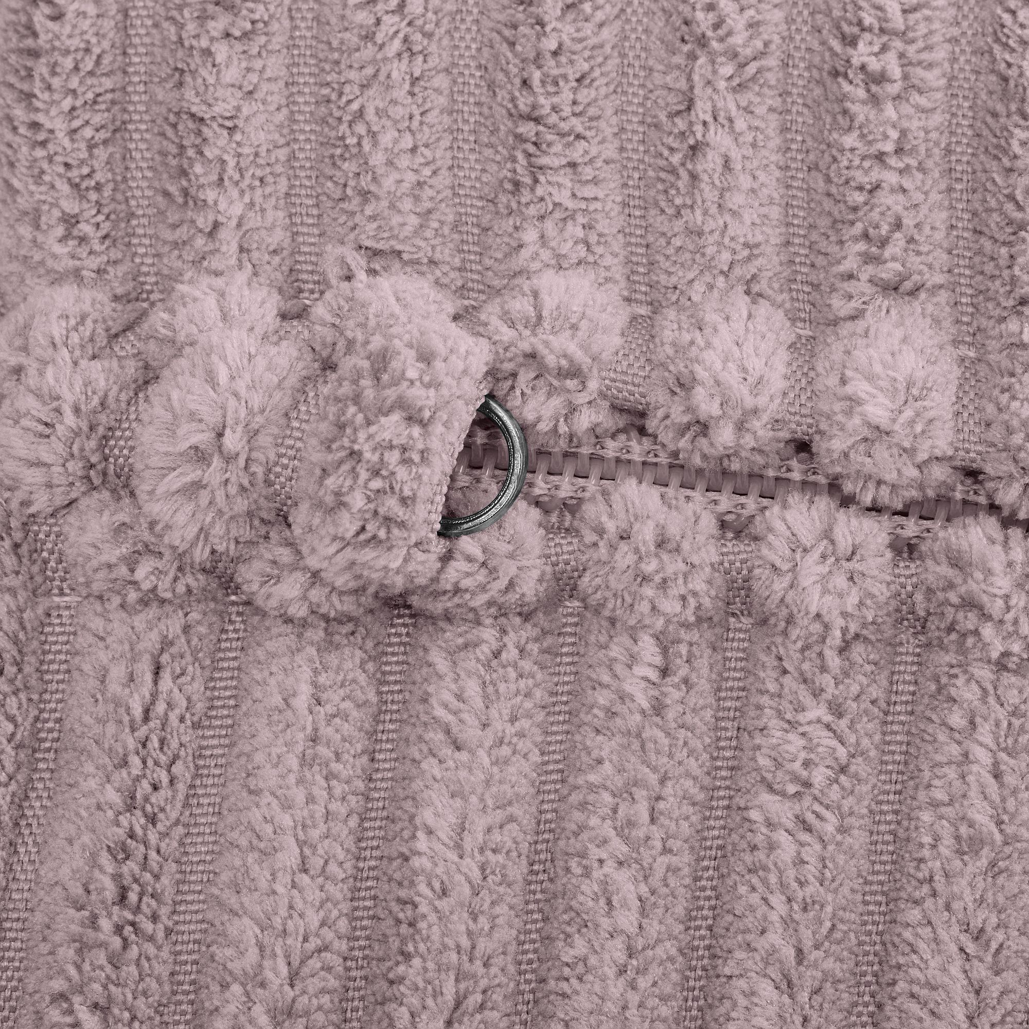 Nahaufnahme eines weichen, strukturierten Reißverschlusses auf einem flauschigen, gestreiften Stoff.