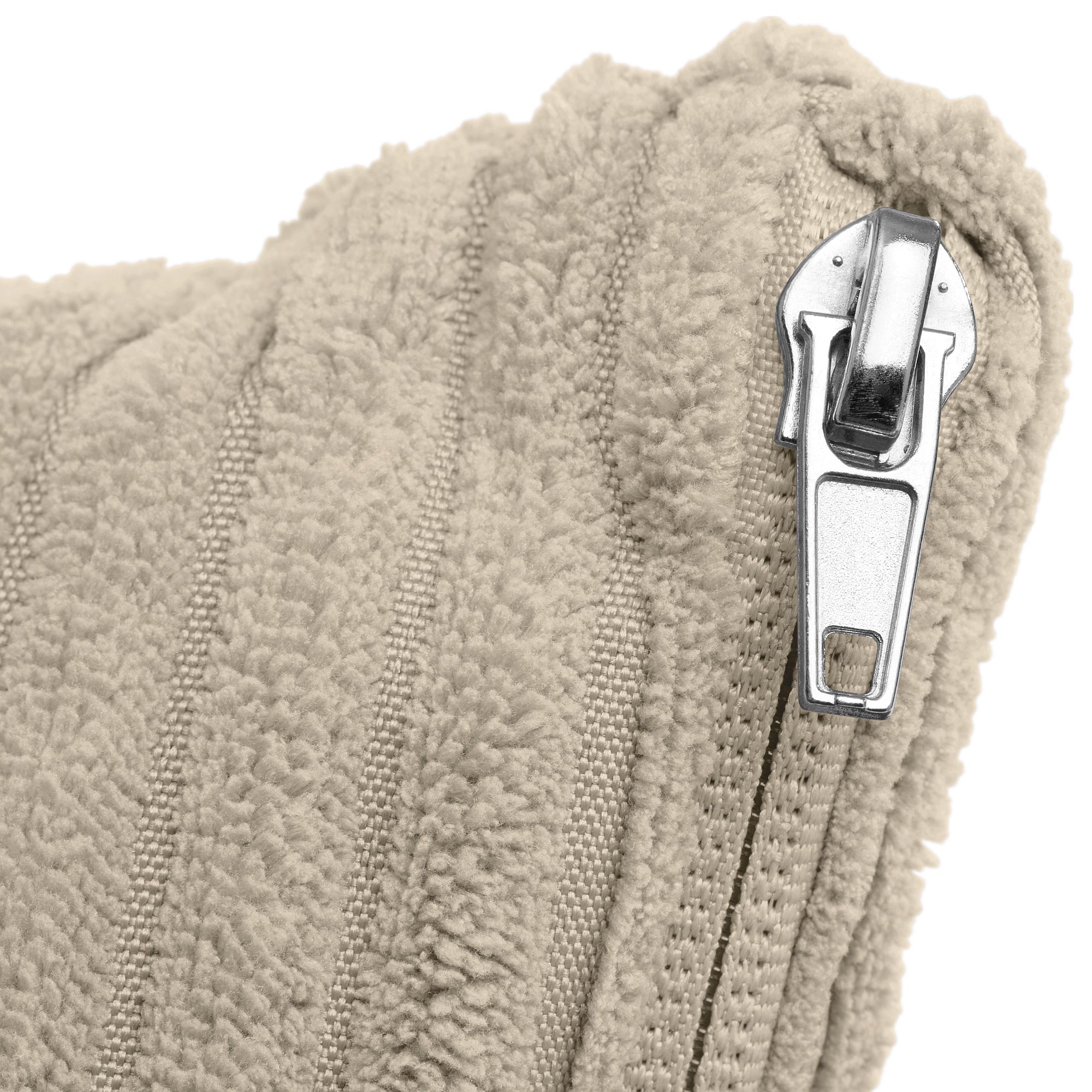 Nahaufnahme eines Metallreißverschlusses auf einem beigen, strukturierten Stoffkissen.