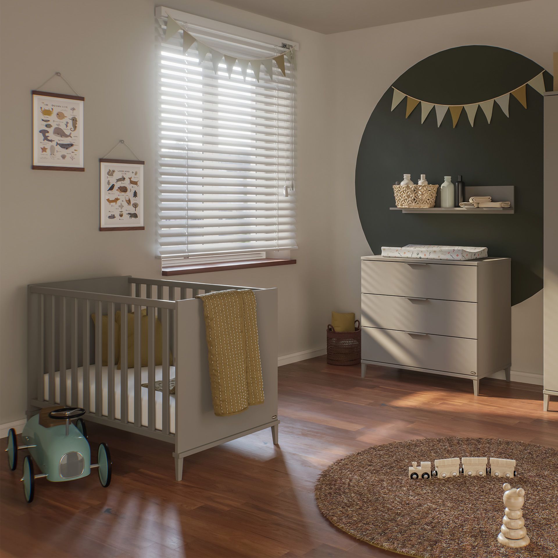 Modernes Kinderzimmer mit einem grauen Kinderbett, einer Kommode und Spielzeug auf einem Holzboden.