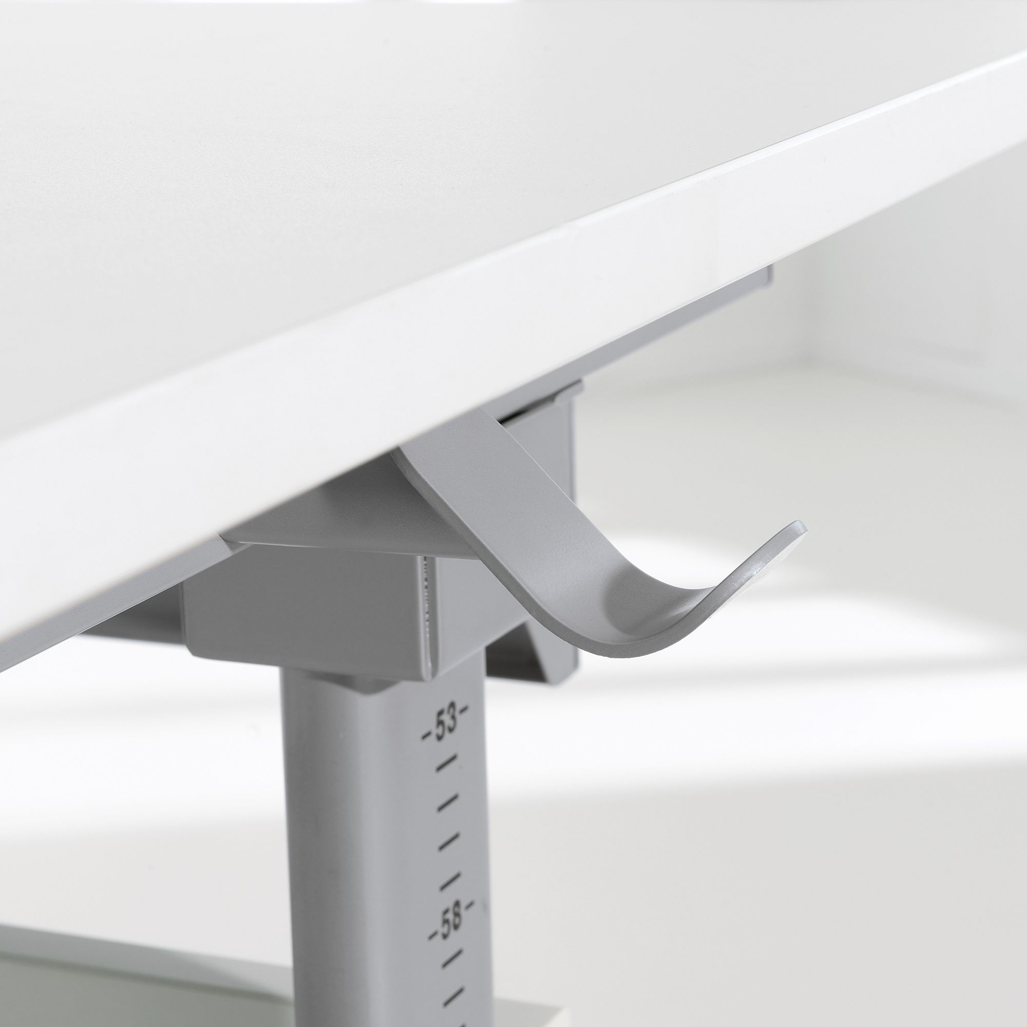 Nahaufnahme eines weißen verstellbaren Schreibtisches mit einem grauen Höhenverstellhebel.